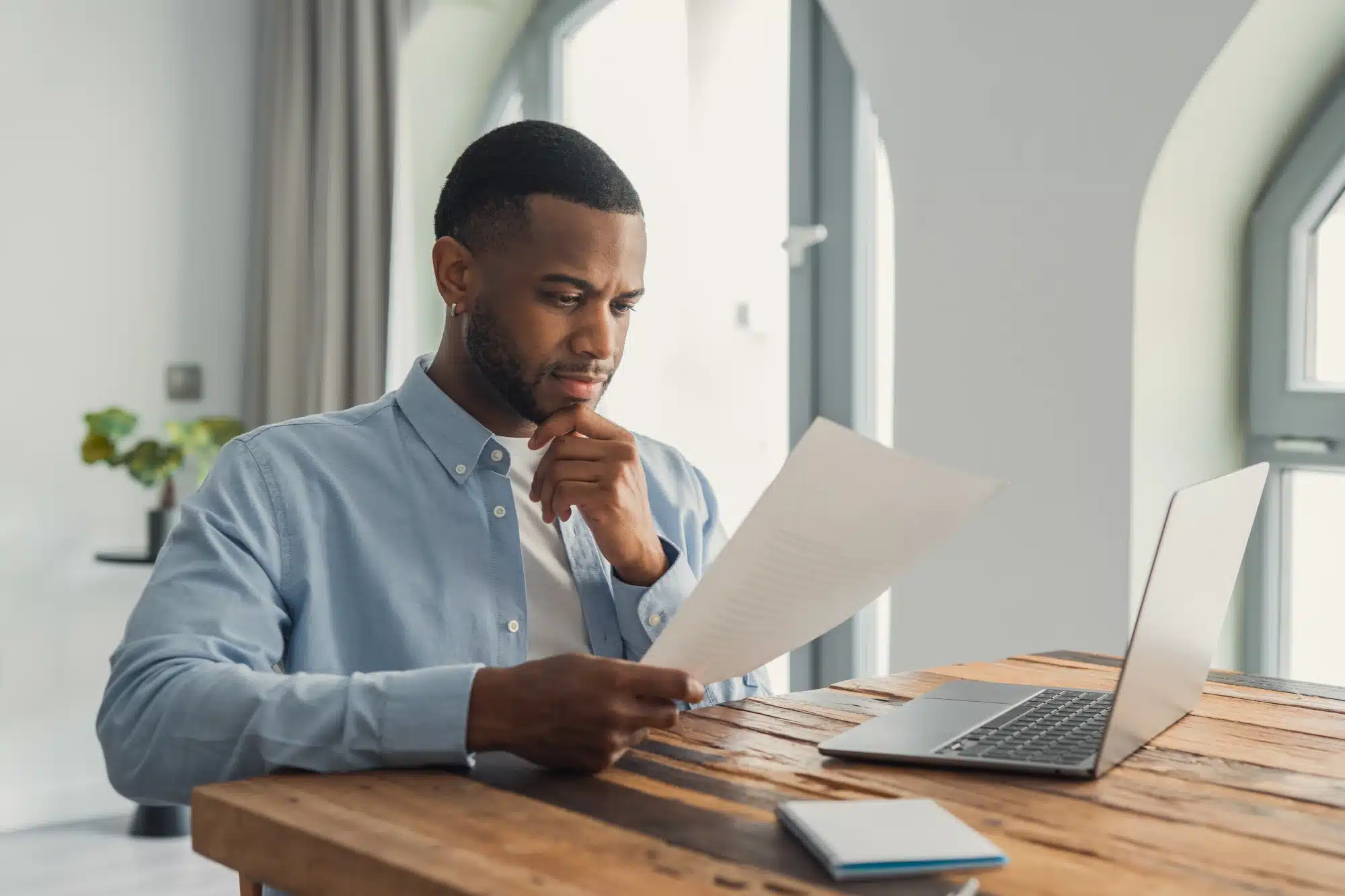 Person reading benefits paperwork at a kitchen table